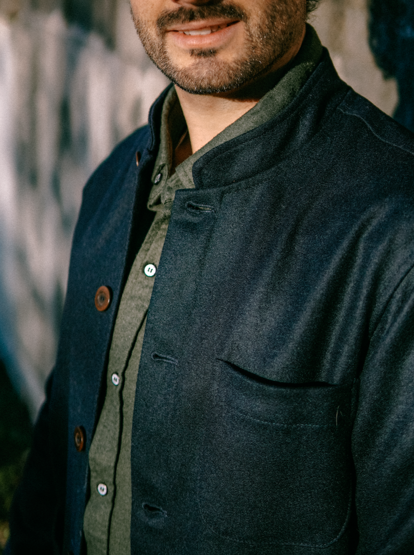 Close-up of the Tambo Wool Jacket in Navy: band collar, brown buttons and chest pocket